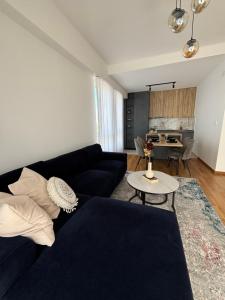 a living room with a black couch and a table at Hug and Fly Apartment in Skopje
