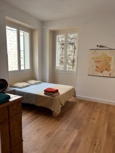 a bedroom with a bed and two windows at Village vacations in Guarguale