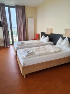 two beds in a hotel room with a balcony at DJH Jugendherberge Xanten in Xanten
