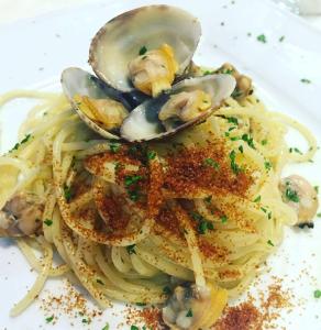 a plate of pasta with oysters and a spoon at Hotel Ristorante Sbranetta in Rozzano