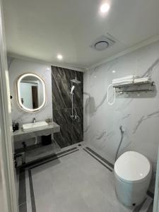 a bathroom with a toilet and a sink and a mirror at Bảo Nhi Paradise Hotel in Làng Môn