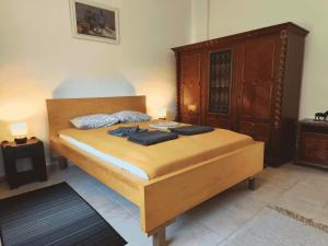 a bedroom with a large bed with a wooden headboard at Minor Major Vendégház in Somogyacsa
