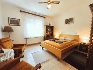 a bedroom with a bed and a living room with a couch at Minor Major Vendégház in Somogyacsa