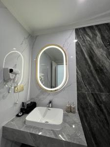 a bathroom with a sink and a mirror at Bảo Nhi Paradise Hotel in Làng Môn