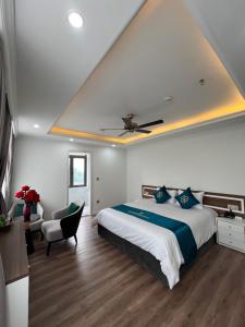 a bedroom with a large bed and a chair at Bảo Nhi Paradise Hotel in Làng Môn