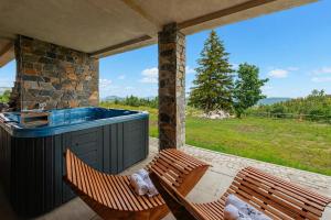 two chairs and a hot tub on a patio at ROGOChalet in Rogojel