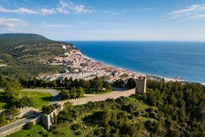 an aerial view of a town on a hill next to the ocean at Kampaoh Sesimbra in Sesimbra