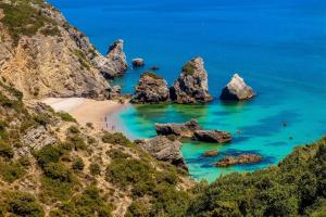 a view of a beach with rocks in the ocean at Kampaoh Sesimbra in Sesimbra