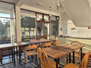 a restaurant with wooden tables and chairs and windows at Ella, Nine Glow Resort in Ella