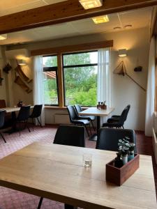 a room with tables and chairs and a large window at Overhalla Hotel in Overhalla 