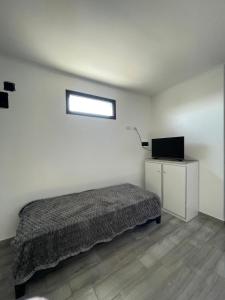 a bedroom with a bed and a television in it at YOJU aparthotel in Colón