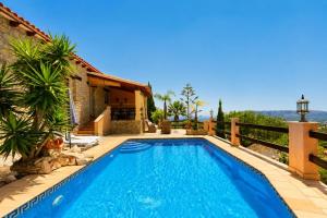 a villa with a swimming pool and a house at Cozy vacation home in Alfaz del Pi
