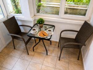 a table with two chairs and a tray of bread at Apartment Be Happy 3, Premium Apartment in Ruse City Centre in Ruse