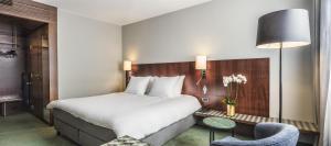 a hotel room with a bed and a chair at NH Brussels EU Berlaymont in Brussels