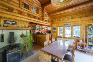 ein Esszimmer mit einem Holztisch und einem Kamin in der Unterkunft La Datcharle in Pugny-Chatenod