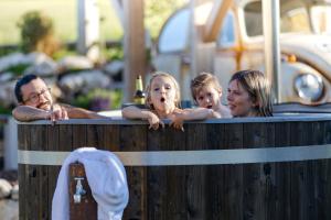 a woman and two children in a hot tub at Chalets Waldeck - Urlaub im Fränkischen Seenland und Altmühltal in Raitenbuch +38 photos