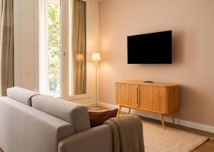 a living room with a couch and a flat screen tv at Limehome Berlin Müllerstraße - Digital Access in Berlin