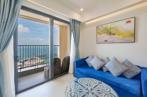 a living room with a blue couch and a balcony at Diamond Suite The Hill Phu Quoc in Phú Quốc