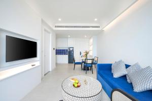 a living room with a blue couch and a table at Diamond Suite The Hill Phu Quoc in Phú Quốc