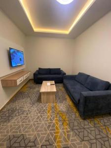 a living room with a blue couch and a table at Golden New Tulip in Abha