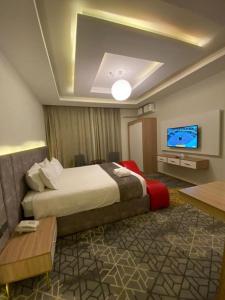 a hotel room with a bed and a flat screen tv at Golden New Tulip in Abha +6 photos