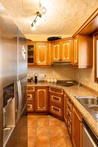 a kitchen with wooden cabinets and a stainless steel refrigerator at Cozy vacation home in Alfaz del Pi