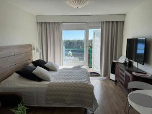 a bedroom with a bed and a tv and a window at Hotelli Terme 616 in Kilvakkala