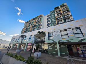 a building with palm trees in front of it at Kingsley at 1 on Albert in Cape Town