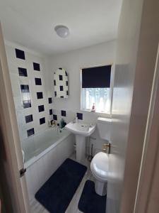a white bathroom with a sink and a toilet at Seabiscuit in Scratby