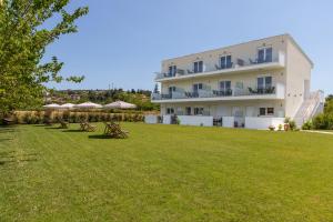 a building with a lawn in front of it at Viento Suites Possidi in Possidi