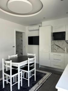 a white kitchen with a black table and chairs at The Rock Hostel in Ponta Delgada