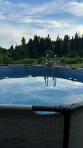 a swimming pool with a reflection of the water at Forest hugs котедж Славсько з джакузі in Khashchovanoye