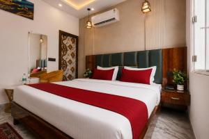 a bedroom with a large bed with red pillows at Hotel The RG Grand Inn Near Chandigarh Railway Station in Chandīgarh