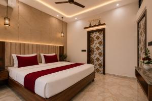 a bedroom with a large bed with red pillows at Hotel The RG Grand Inn Near Chandigarh Railway Station in Chandīgarh +11 photos