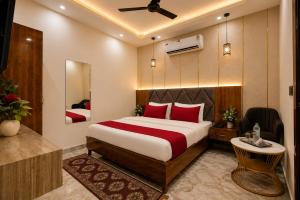 a bedroom with a large bed with red pillows at Hotel The RG Grand Inn Near Chandigarh Railway Station in Chandīgarh