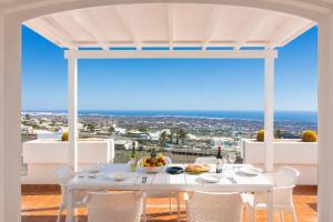 a white dining room with a view of the ocean at Villa Oasis de Asomada in La Asomada