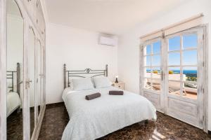 a white bedroom with a bed and a window at Villa Oasis de Asomada in La Asomada +35 photos