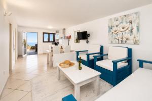 a living room with blue and white chairs and a table at Villa Oasis de Asomada in La Asomada
