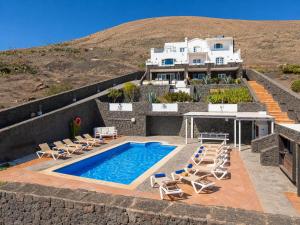 a house with a swimming pool and chairs and a house at Villa Oasis de Asomada in La Asomada