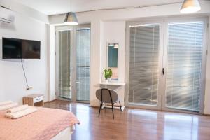 a bedroom with a bed and a desk and some windows at White & Wood in Bitola