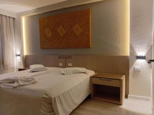 a bedroom with a large bed and a painting on the wall at Ambassador Residence Apart-hotel in Curitiba +26 photos