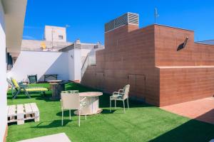 a patio with a table and chairs on the grass at Casa Yaye Ecija in Écija