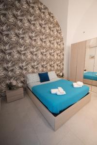 a bedroom with a blue bed with towels on it at La VILLA in Modugno