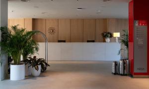 an office with a reception desk and potted plants at AQUA Hotel Promenade & Spa 4Sup in Pineda de Mar +148 photos