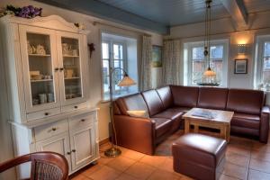 a living room with a couch and a table at Reethuus am Fething in Langeneß