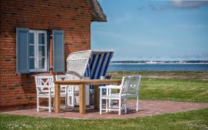 a group of chairs and a table on a patio at Reethuus am Fething in Langeneß +22 photos