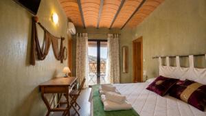 a bedroom with a bed with a desk and a table at Hotel Finca Aldabra in Pinos Genil +66 photos