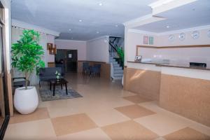 eine Küche und ein Wohnzimmer mit einem Tisch und einer Pflanze in der Unterkunft Mika Hotel Kabulonga in Lusaka + 7 Fotos