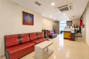 a living room with a red couch and a table at Collection O Near Tanjung Batu Formerly 4orty Inn in Bintulu
