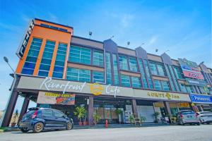 a large building with cars parked in front of it at Collection O Near Tanjung Batu Formerly 4orty Inn in Bintulu